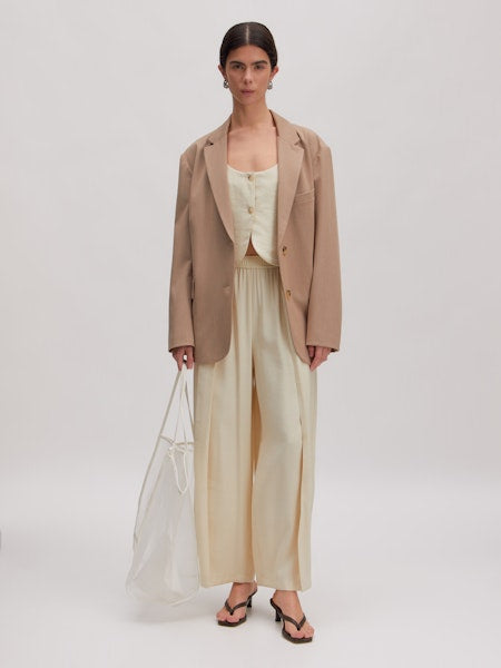 Quanda Trousers von EDITED – gestylt im Office-Look, kombiniert mit Bluse/Top/Blazer
