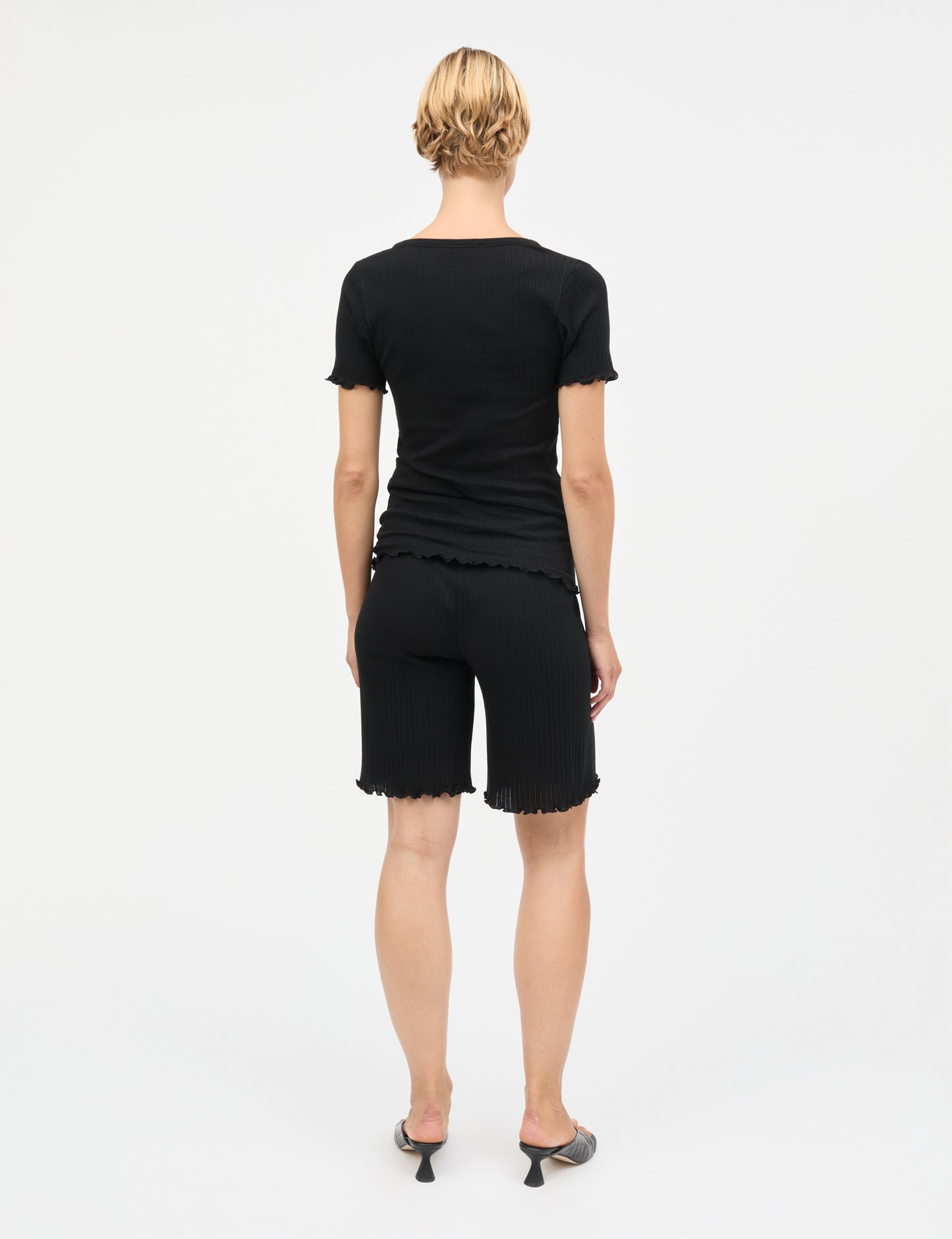 Pointella Lilly Shorts von Mads Nørgaard in Schwarz – getragen von Model, Rückansicht mit Rüschensaum