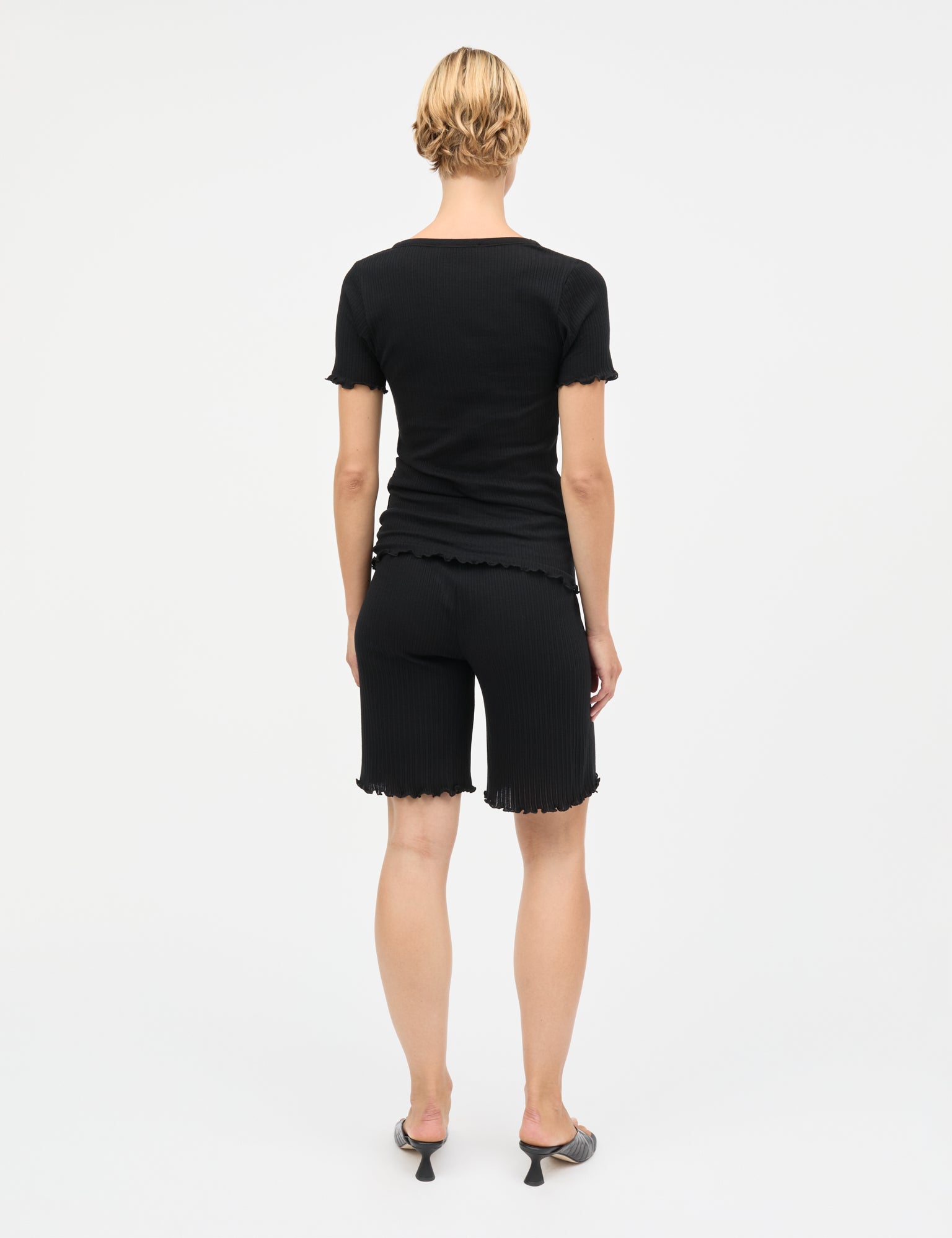 Pointella Lilly Shorts von Mads Nørgaard in Schwarz – getragen von Model, Rückansicht mit Rüschensaum