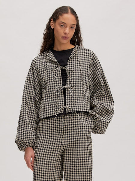 Model trägt die karierte Lisanne Blouse von Edited im legeren Look